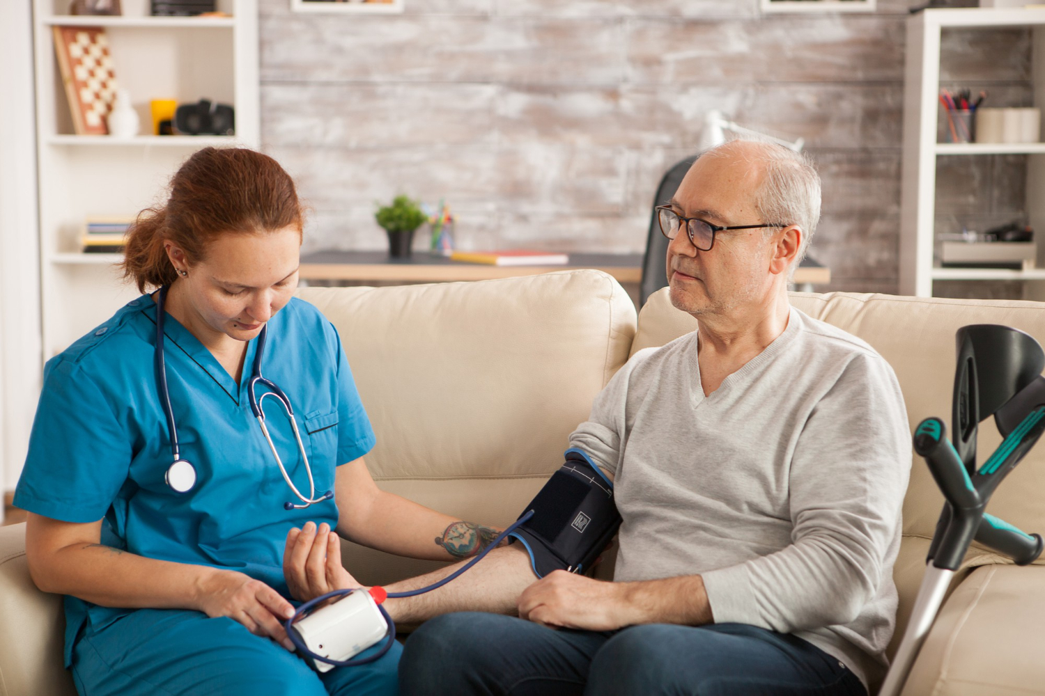 female-doctor-nursing-home-checking-old-man-blood-pressure